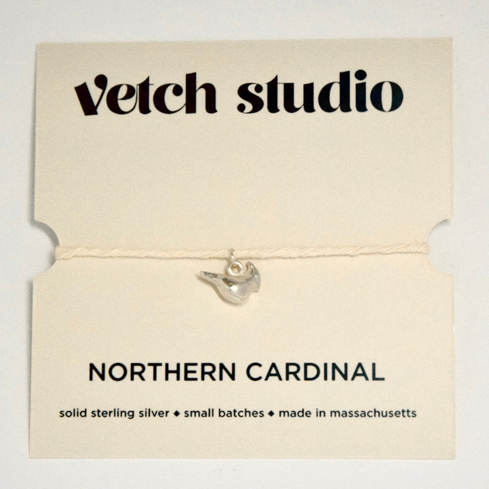 Silver Northern Cardinal pendant on a card with 'Vetch Studio' branding on a light gray background