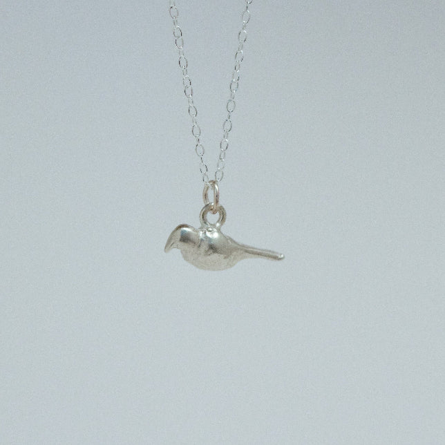 product image of a sterling silver crow charm on a chain necklace facing left