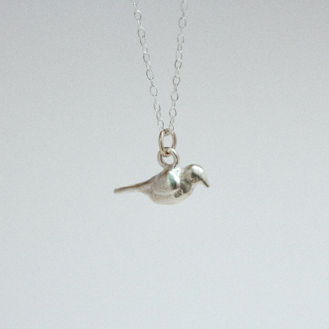 sterling silver crow charm on a chain facing right