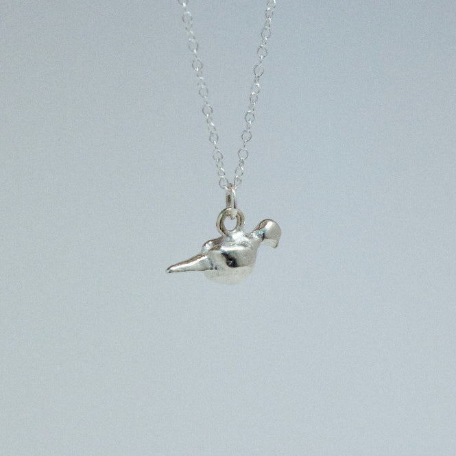 Silver bird pendant necklace on a light gray background