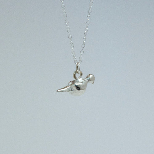 Silver bird pendant necklace on a light gray background